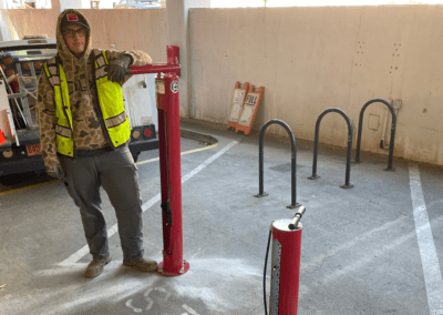 A man in yellow vest standing next to red posts.