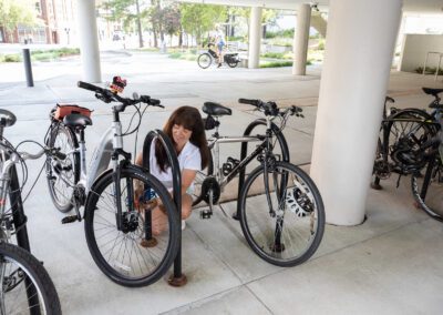 A woman is leaning against two bikes