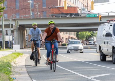 Two people riding bikes on a city street