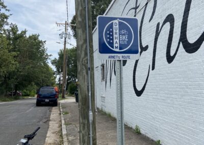 A bicycle parked on the side of a road next to a street sign.